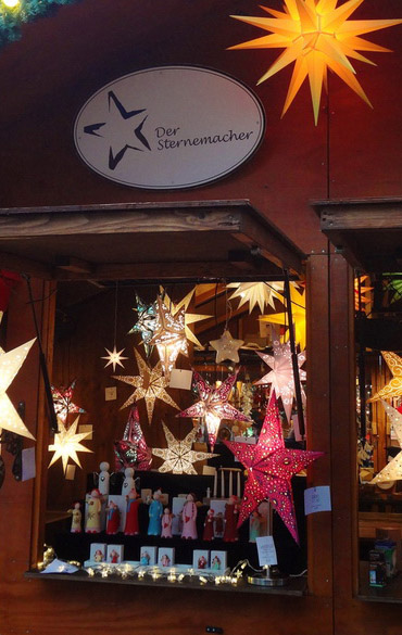 Standluke mit beleuchteten Weihnachsternen und Holzfiguren Standluke mit beleuchteten Weihnachsternen und Holzfiguren