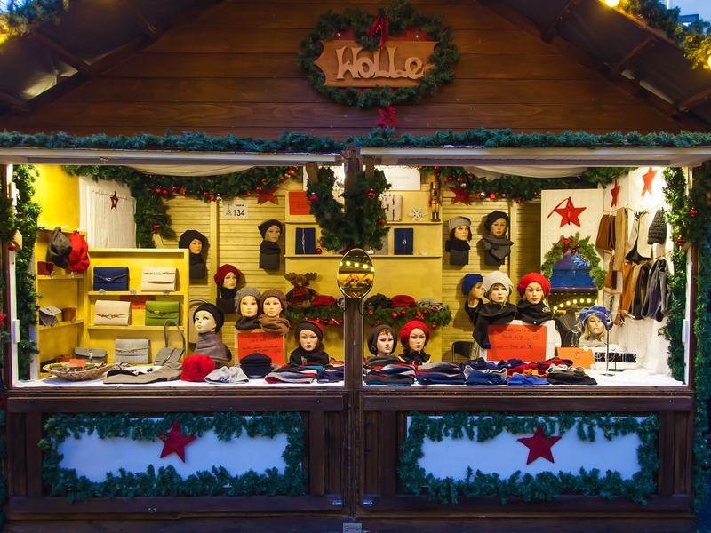 Weihnachtsmarktstand mit Wollsachen wie Mützen und Schals und individuellen und farbenfrohen Buch oder Hefteinbänden Stand von vorne mit Wollsachen wie Mützen und Schals