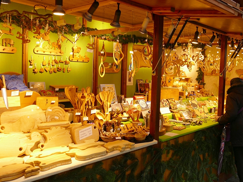 Holzwaren-Stand Aufgeräumter Stand mit Holzbrettchen, Löffeln und Deckenschmuck